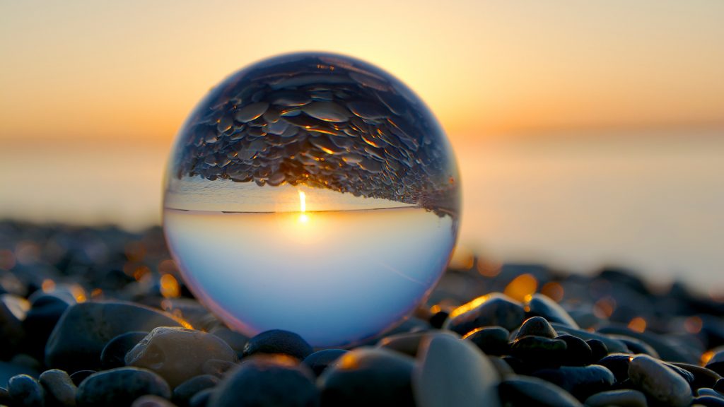 Morning art with glass ball on pebble beach, Larnaka, Cyprus
