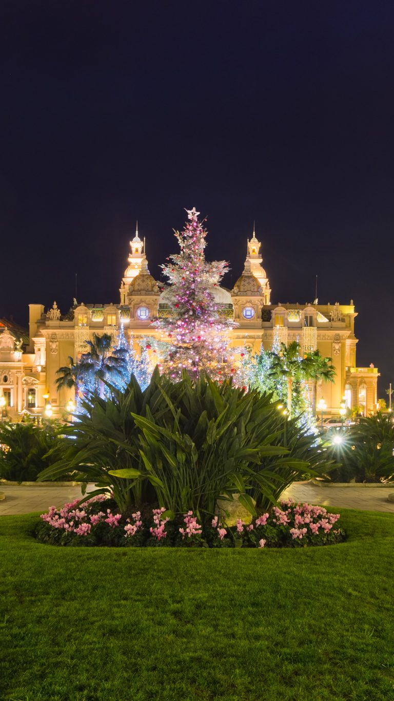 Christmas tree in front of the palace of casino of Monaco at dusk ...