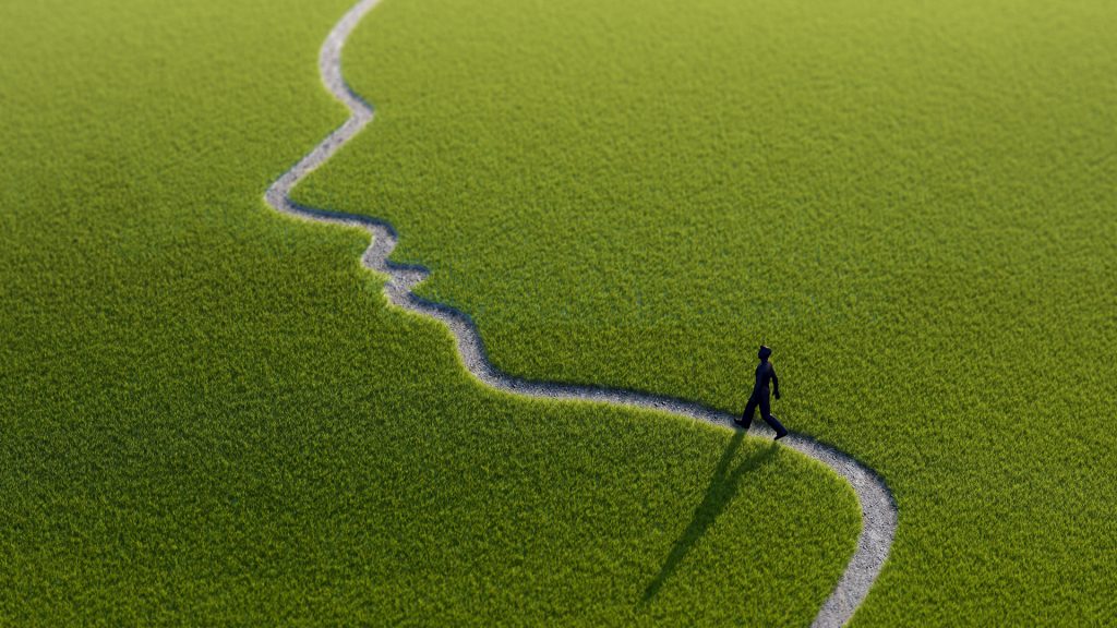 Lonely person walking along face-shaped path artwork