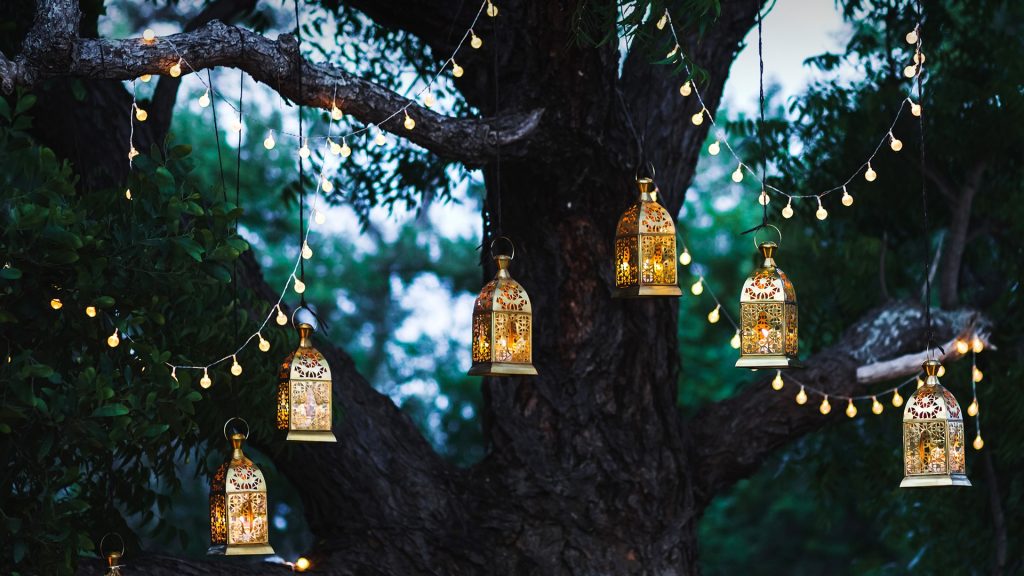 Night wedding ceremony with a lot of candles and vintage lamps on big tree, Bali, Indonesia