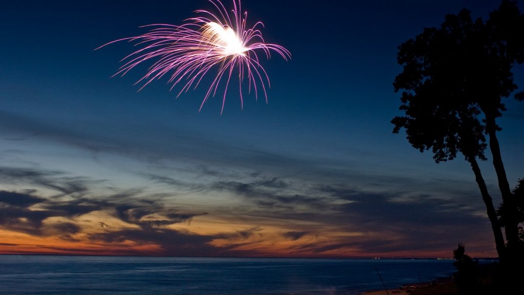 Fireworks on a beach at sunset