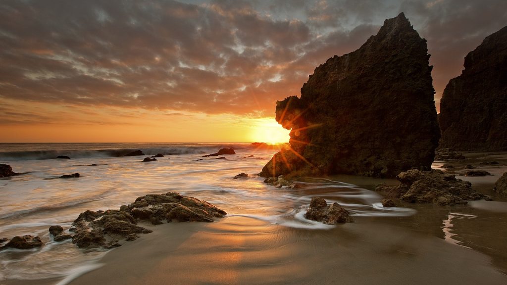 The last rays of the day shine at Malibu beach in California, USA