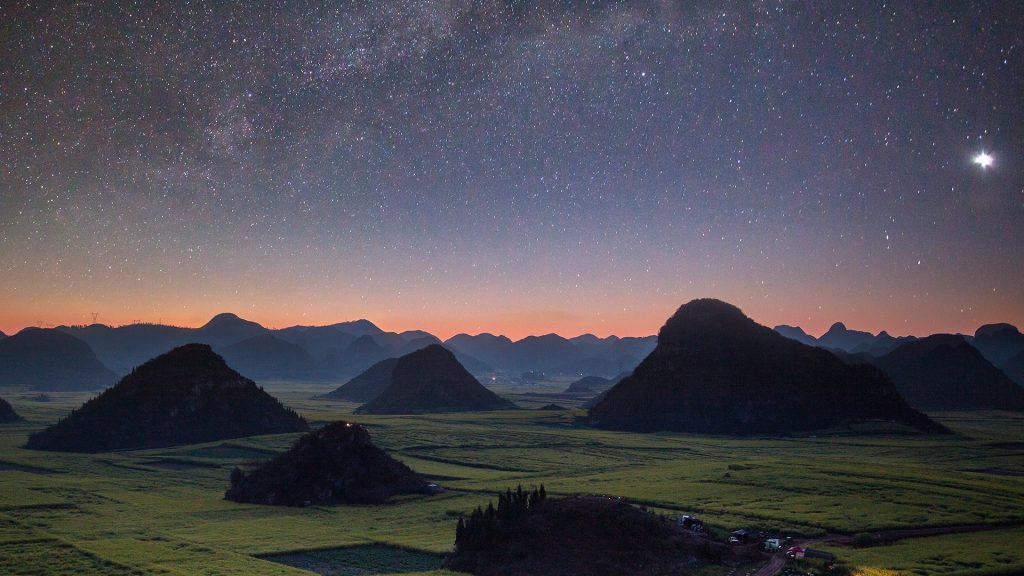 Milky way over yellow rapeseed flower field, Luoping, China