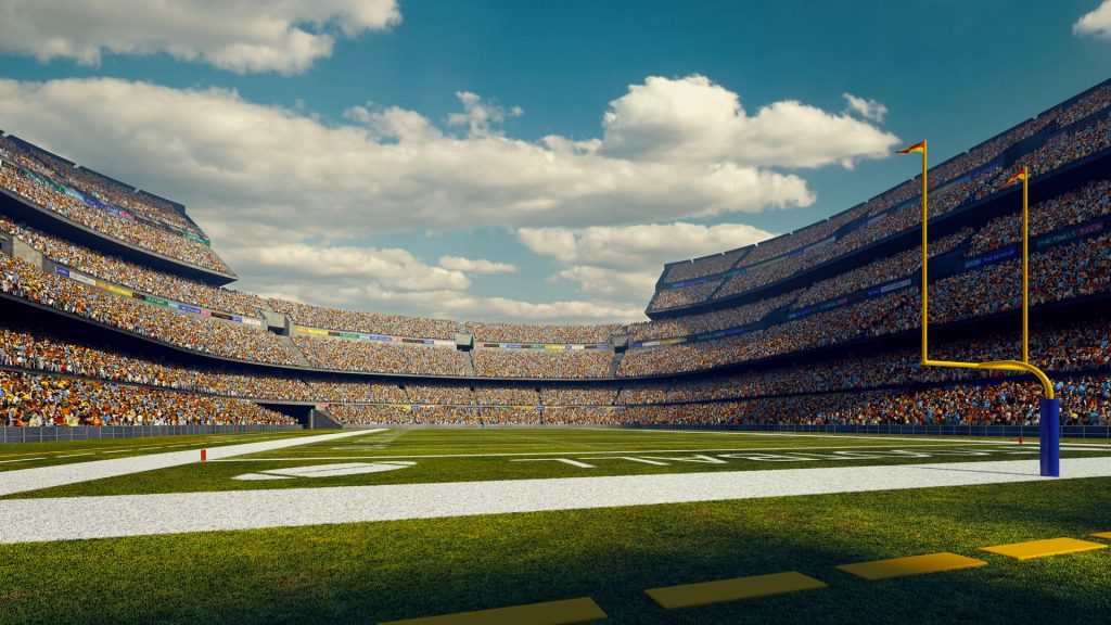 Sunny american football stadium full of spectators under blue sky