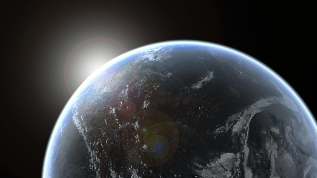 Sun emerging over planet earth