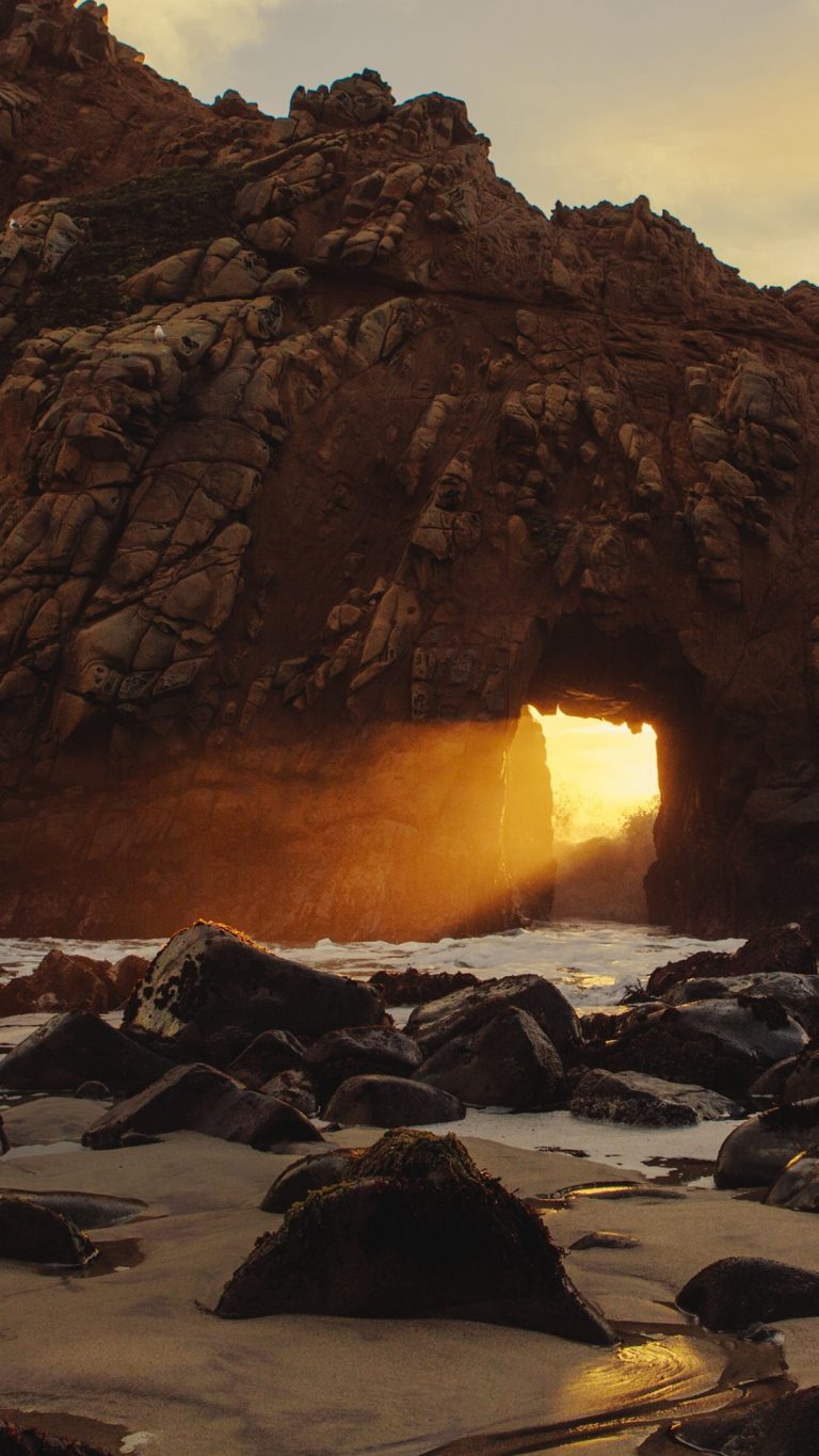 Sunset glowing through rock  formation on Pfeiffer Beach  