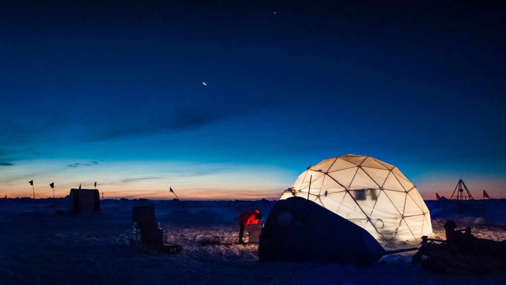 Researcher working at an ice camp under clear polar sky, Weddell Sea, Antarctica