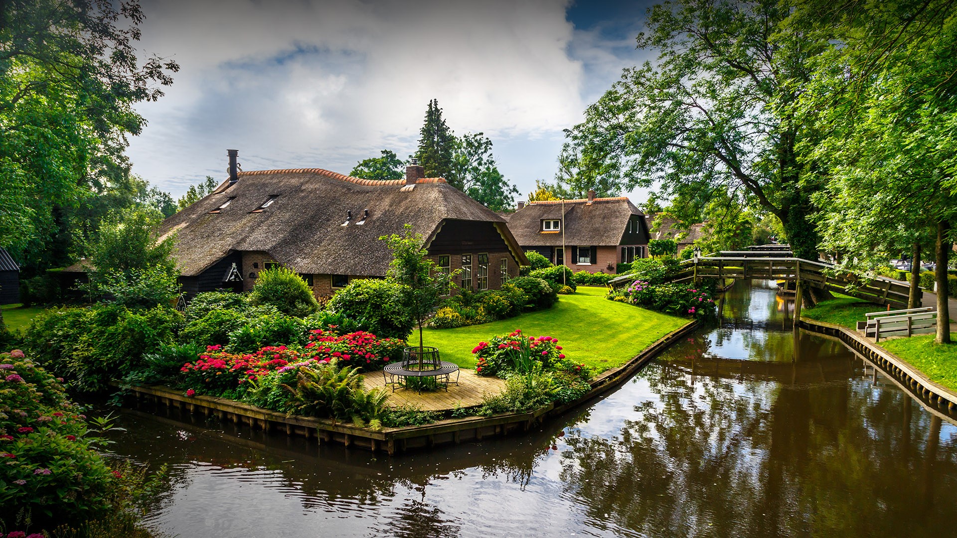 View of Giethoorn village with canals and rustic thatched roof houses ...