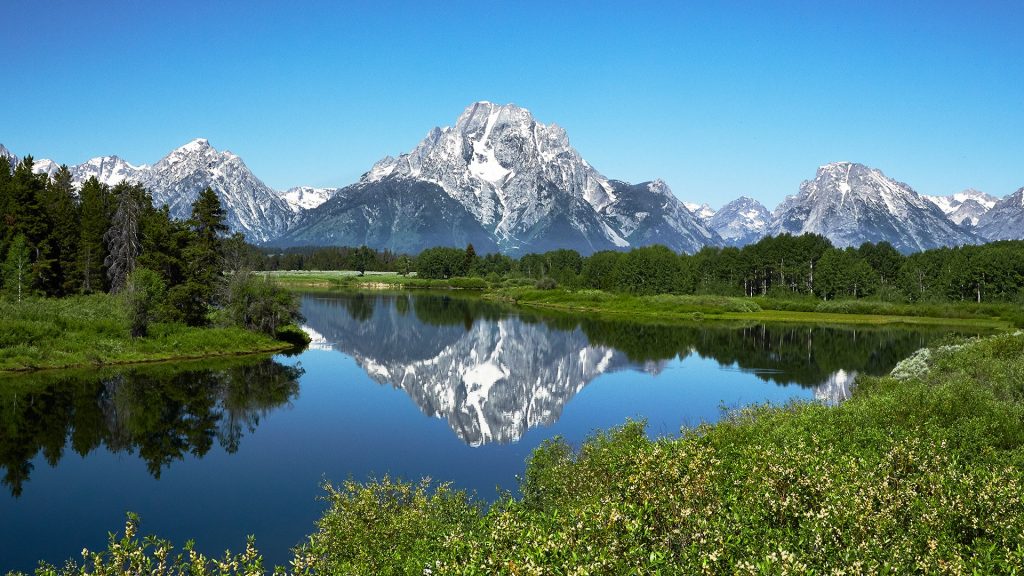 Grand Tetons reflected in still water of the Snake River at Oxbow Bend, Wyoming, USA