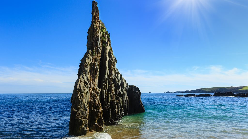 Ocean coastline landscape with pointed rock at sandy Mexota beach, Asturias, Spain