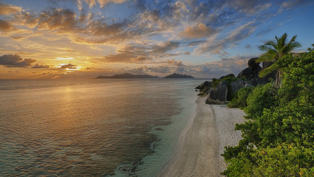 Anse Source d'Argent view with sculpted rocks and palm trees at sunset, La Digue, Seychelles