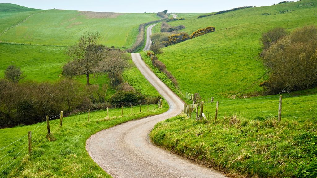 Country road, dirt track trough rural landscape, England, UK
