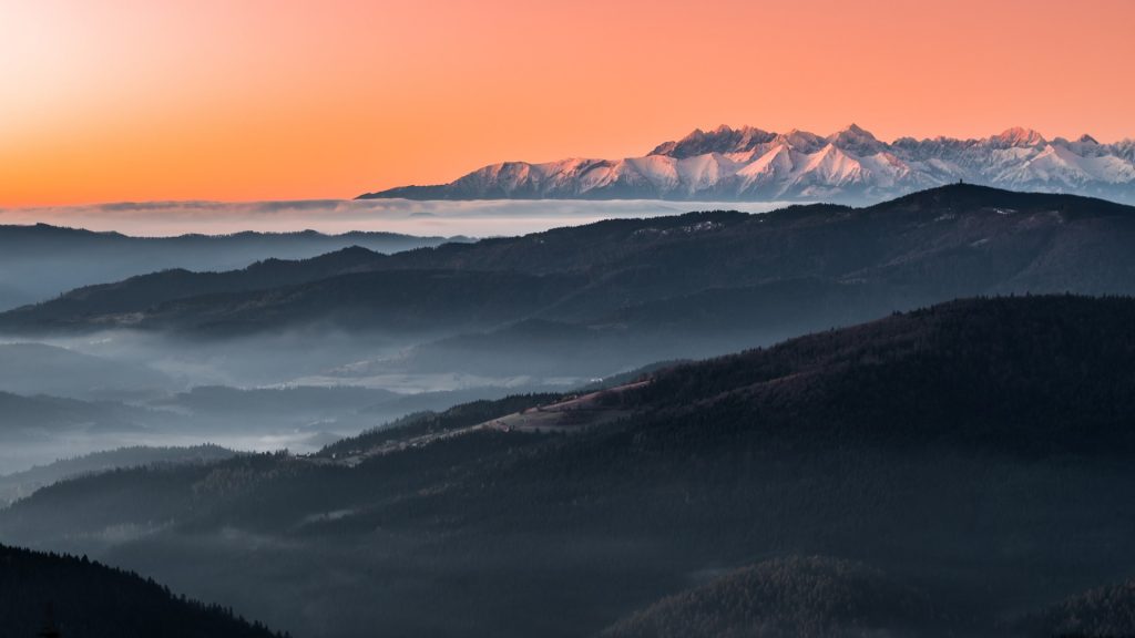 View over misty Gorce to snowy Tatra mountains in the morning, Poland