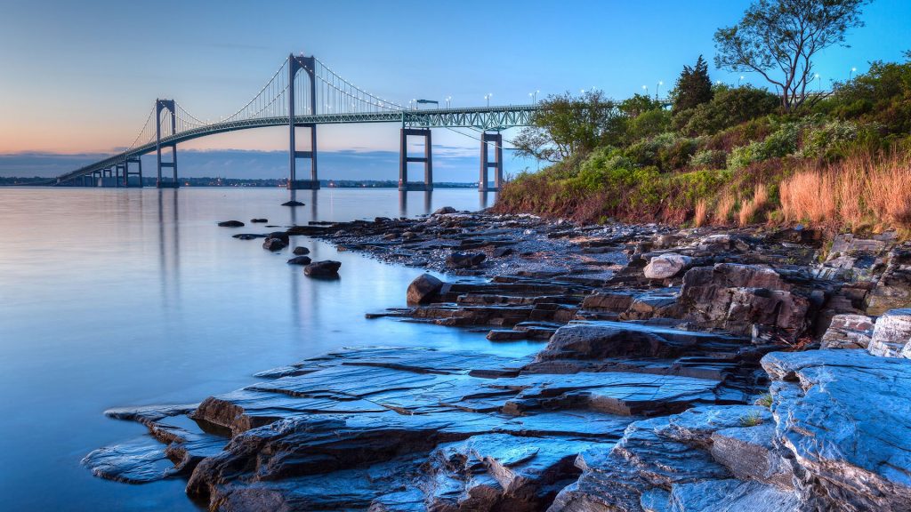 Claiborne Pell Newport Bridge with rocky seascape at sunrise, Jamestown, Rhode Island, USA
