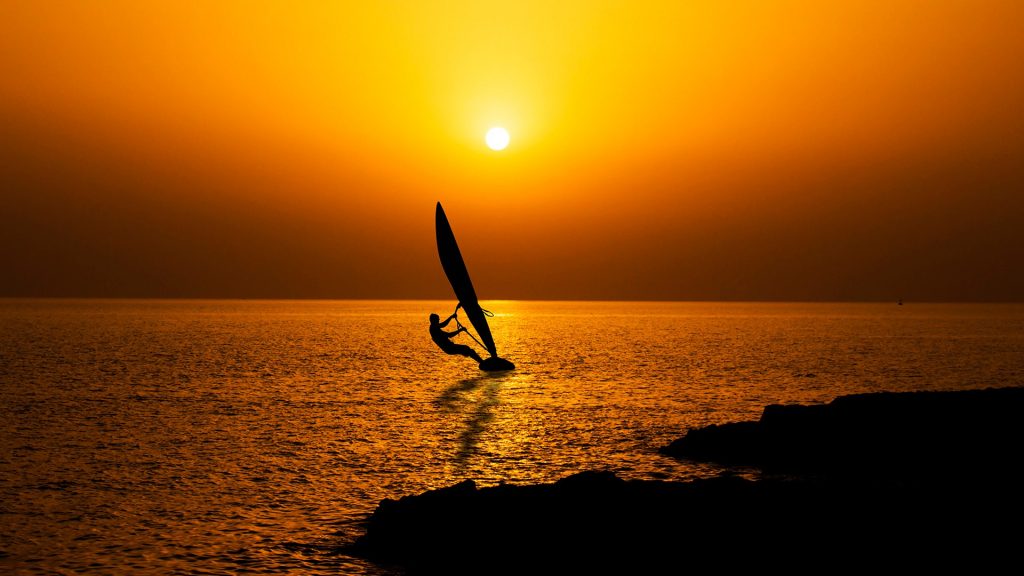 Sea boatman silhouette at sunset