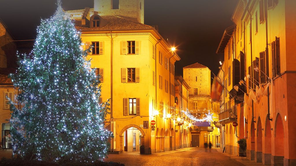 Illuminated Christmas tree on central plaza in historic part of Alba, Italy