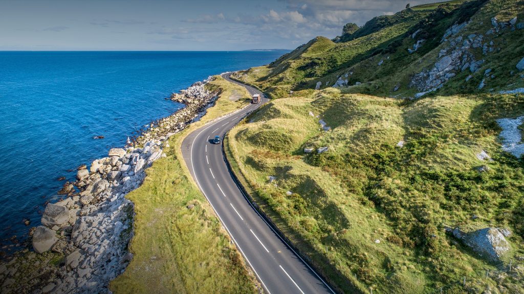 Causeway Coastal Route (Antrim Coast Road) with cars on coast of Northern Ireland, UK