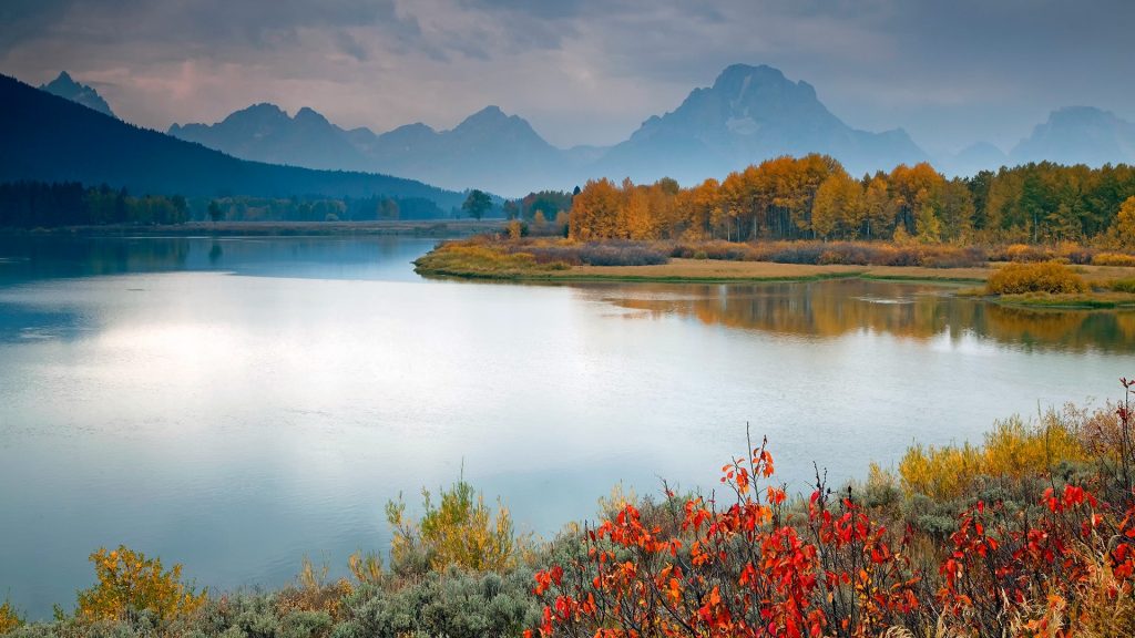 Rural landscape reflected in still Snake river, Oxbow Bend, Grand Teton NP, Wyoming, USA