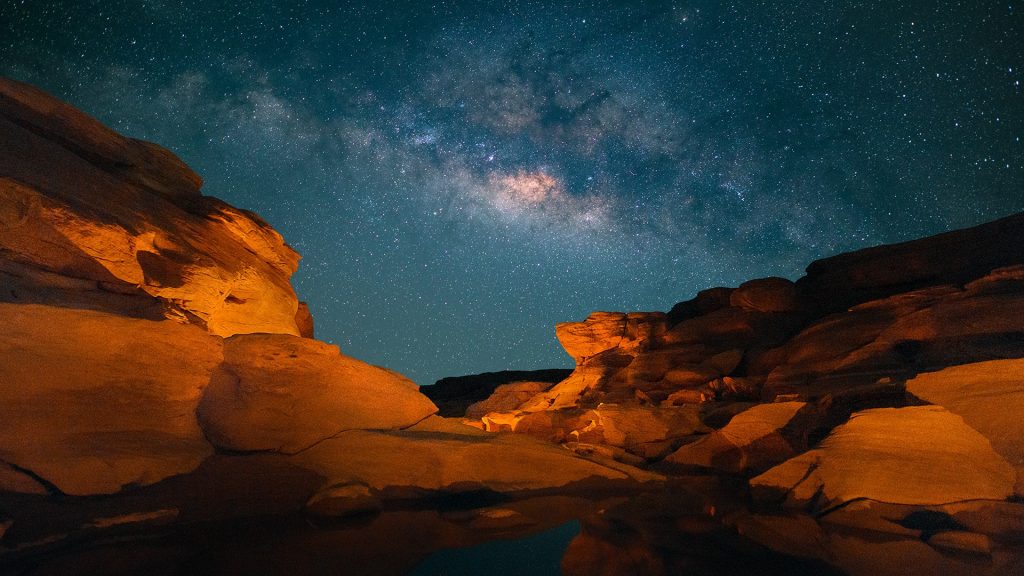 Milky way over landscape of rock field at Sam Pan Bok during night, Thailand