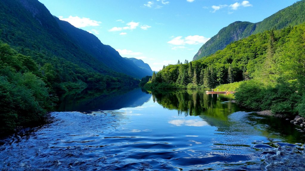 Scenic view of river amidst mountains against sky, Quebec, Canada