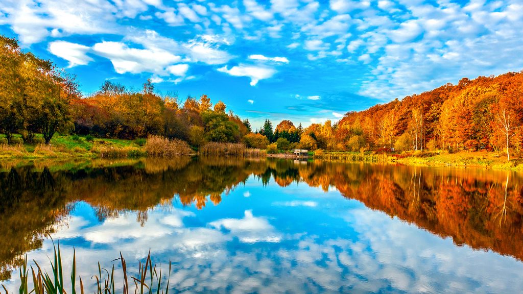 Lake reflecting sky in autumn landscape, Massachusetts, USA