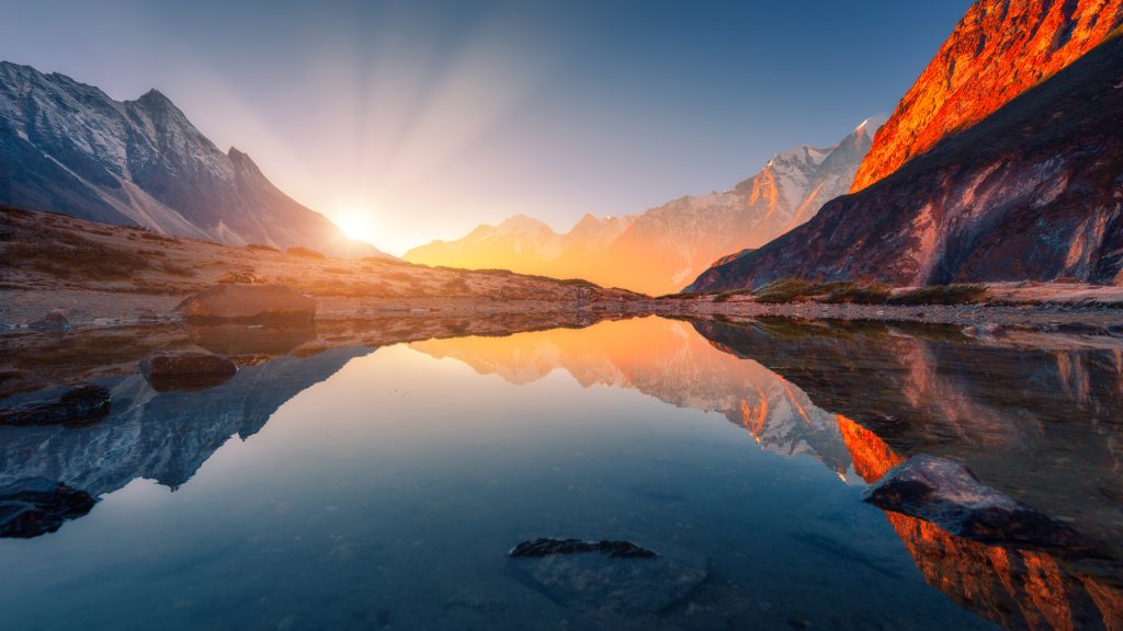 Mountain landscape with illuminated peaks and lake at sunrise, Himalayas, Nepal