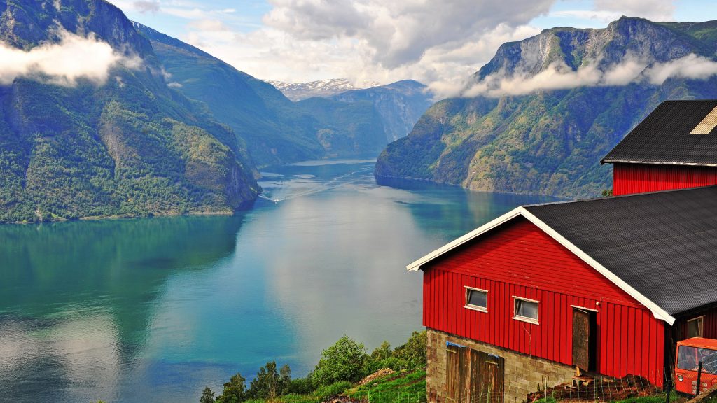 Red scandinavian house over Sognefjord, Aurland, Vestland county, Norway
