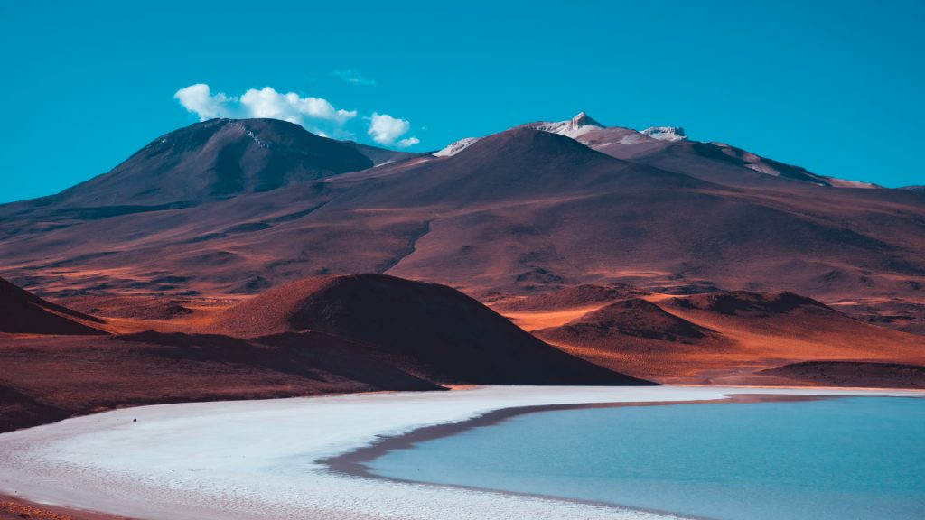 Red volcanic mountains and a blue salt lake in desert, San Pedro de Atacama, Chile