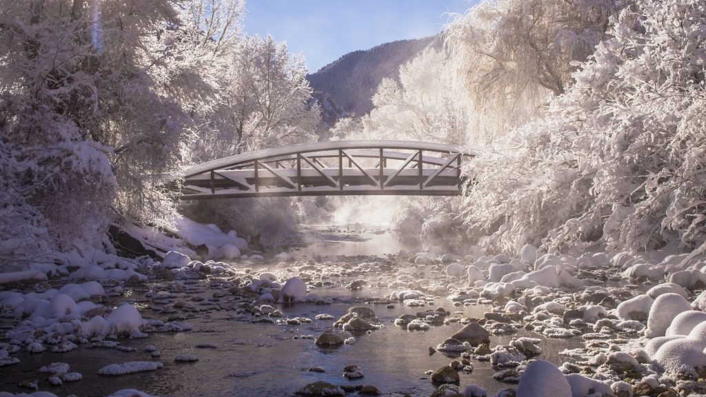 View of bridge over stream in winter, Colorado, USA