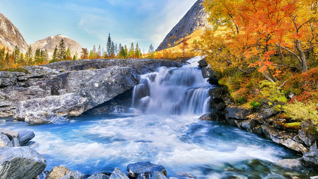 Beautiful autumn mountain landscape with yellow trees and waterfall