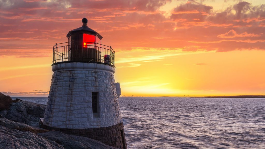 Castle Hill Lighthouse in orange sunset, Narragansett Bay in Newport, Rhode Island, USA