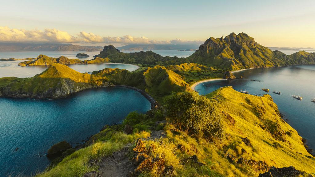 Boats moored in the bay at Padar Island in Komodo National Park at sunset, Indonesia