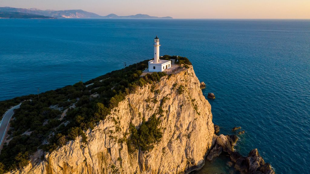 Aerial view of a lighthouse surrounded by steep cliffs at Cape Ducato, Lefkada Island, Greece