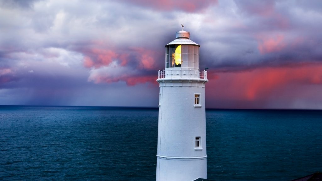 Trevose Head lighthouse under cloudy sky at sunrise, Cornwall, England, UK