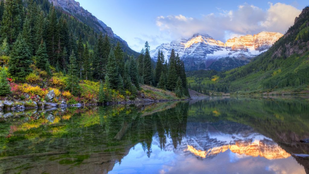 Reflection of snow capped Maroon Bells in fall at sunrise, Colorado, USA