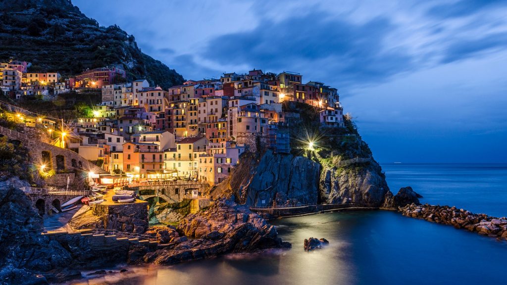 View of cityscape against cloudy sky, blue hour in Manarola, Cinque Terre, Italy