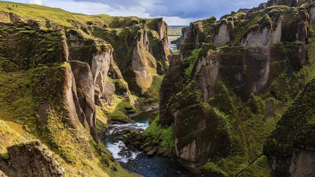 Scenic view of waterfall in Fjaðrárgljúfur canyon on Fjaðrá river against sky, Iceland