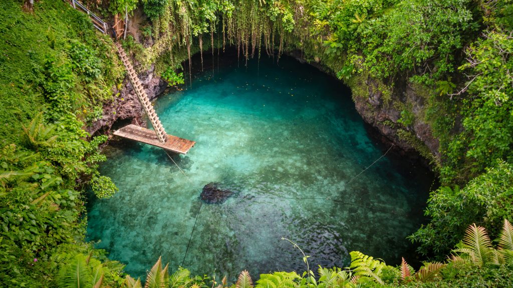Natural pool with emerald water in the middle of tropical jungle, To Sua Ocean Trench, Samoa