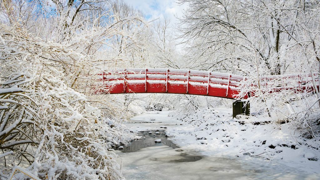 Fresh snowfall on red bridge, Thomas Mitchell Park, Mitchellville near Altoona, Iowa, USA
