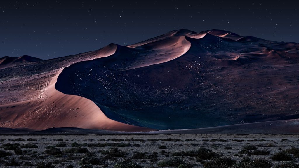 Desert of Namib at night with orange sand dunes and starry sky