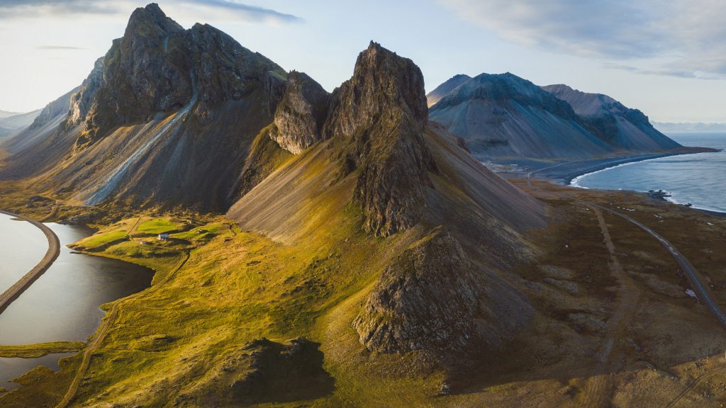 Landscape aerial panorama with mountains and coast at sunset, scenic road in Iceland