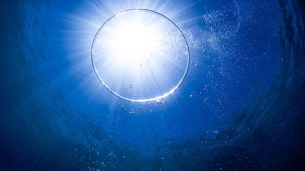 Circle created with a bubble below the sea level, underwater world of Maldives