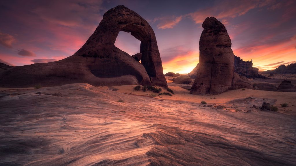 Sunset with arch rock formations in desert, Haʼil region, Saudi Arabia