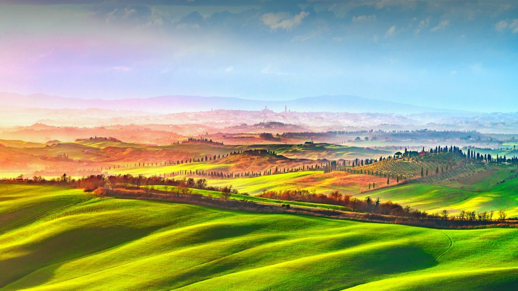 Siena city panoramic skyline, countryside and rolling hills in a misty day, Tuscany, Italy