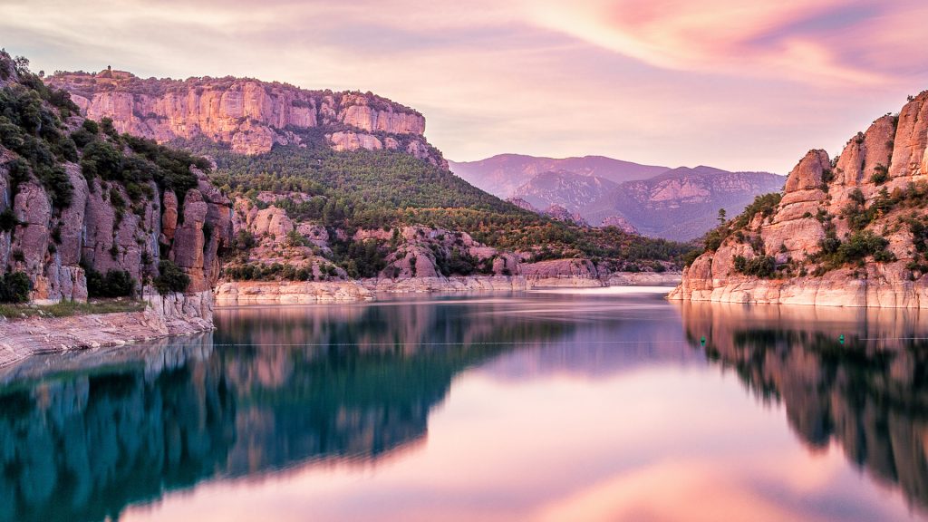 Sunset over Llosa del Cavall reservoir with blurry water and mountains, Catalonia, Spain
