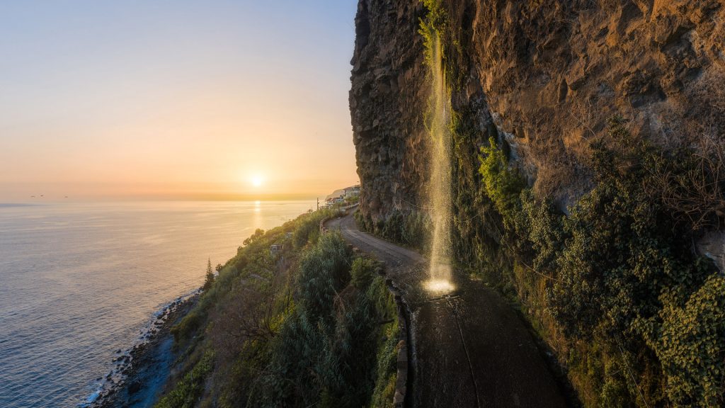 Waterfall on coastal road at summer sunset, Madeira island, Portugal