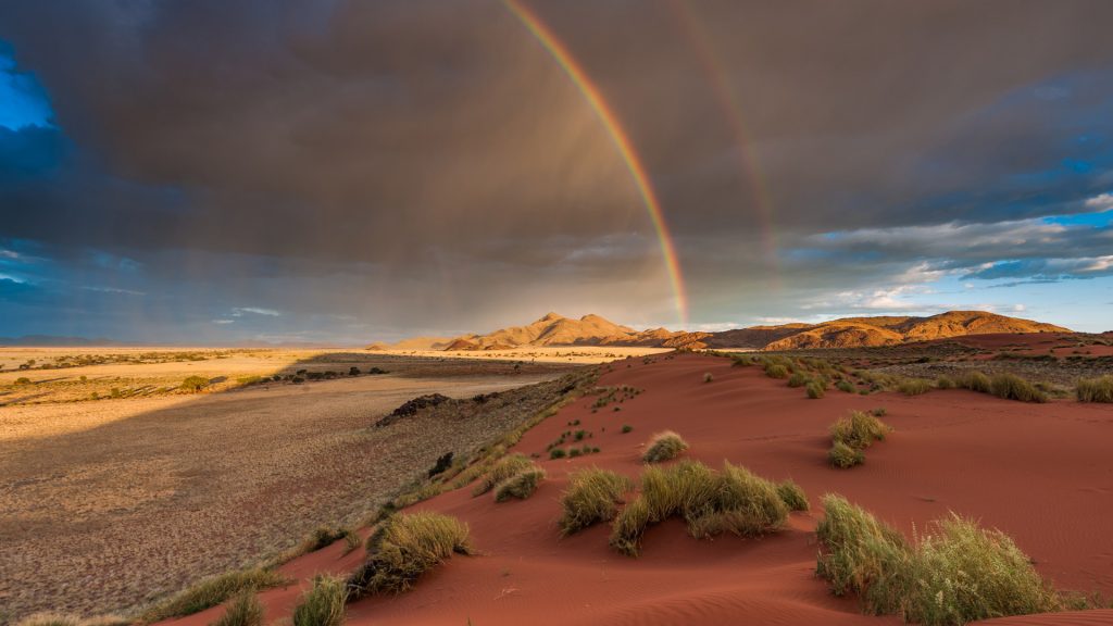 Rainbow across desert and mountains during a storm, NamibRand Nature Reserve, Namibia