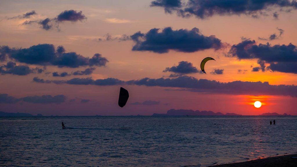 Silhouette people kitesurfing with sunset clouds, Koh Phangan, Thailand