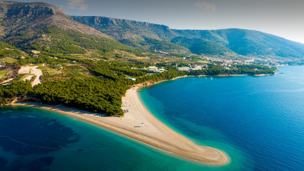 View of coastline with peninsula and town, Bol town, Zlatni Rat, Dalmatia, Croatia